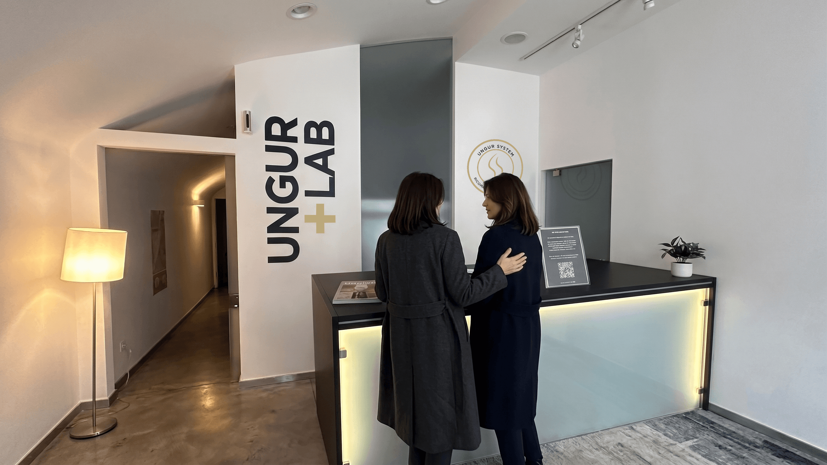 La reception dell'istituto UNGUR+LAB a Bolzano, con due donne al bancone